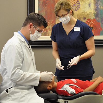 Orthodontist and assistant treating patient