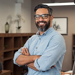 Man with glasses smiling in office