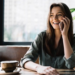 Woman smiling while talking on phone in cafe