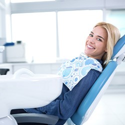 Woman smiling while sitting in dental chair