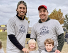 Two men and two kids standing outside smiling