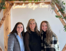 Three women standing and smiling